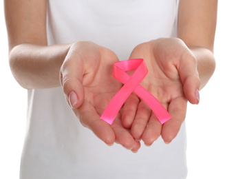 Woman holding pink ribbon on white background, closeup. Breast cancer awareness