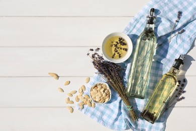 Different cooking oils and ingredients on white wooden table, flat lay. Space for text