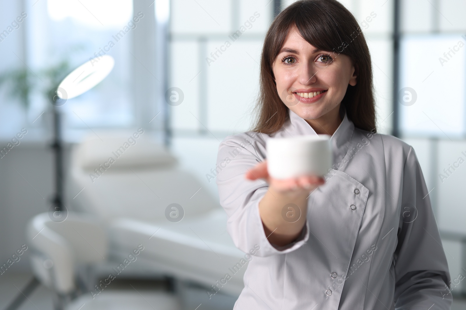 Photo of Cosmetologist with cosmetic product in clinic, selective focus. Space for text