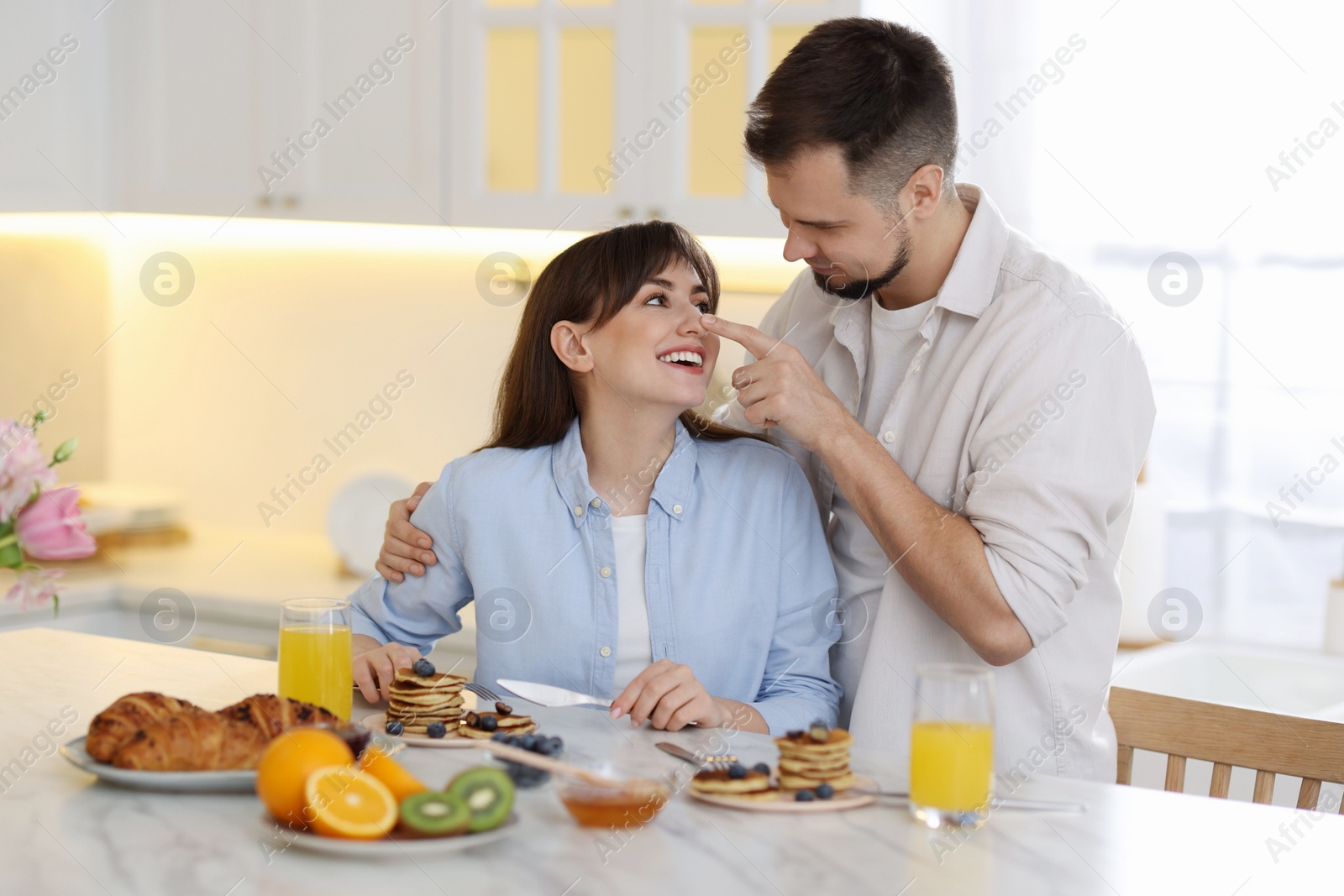 Photo of Happy couple spending time together during breakfast at home