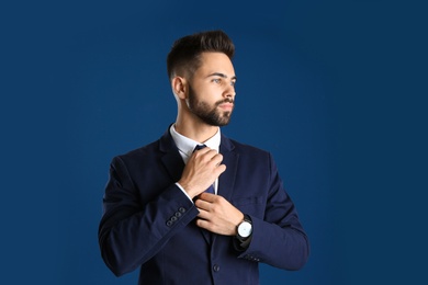 Photo of Portrait of handsome young man in office suit on color background