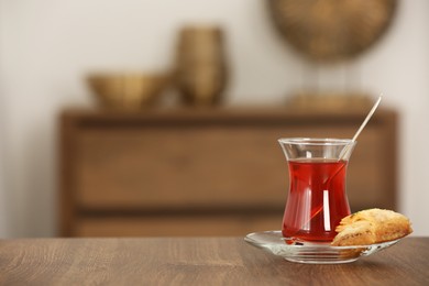 Photo of Tasty Turkish tea and baklava on wooden table indoors, space for text