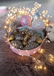 Beautiful Christmas tree baubles and fairy lights on faux fur