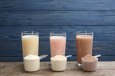 Photo of Protein shakes and powder on wooden table