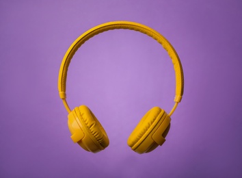 Photo of Wireless headphones with earmuffs on color background