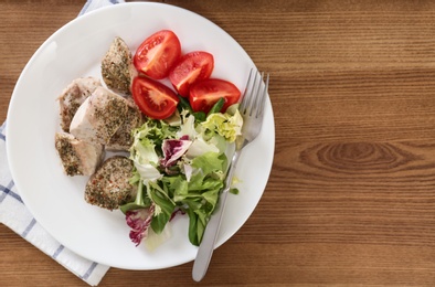 Delicious chicken with vegetables and space for text on wooden table, top view. Multi cooker recipes