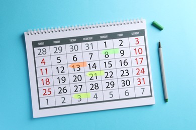 Photo of Timetable. Calendar with marked dates and pen on light blue background, top view