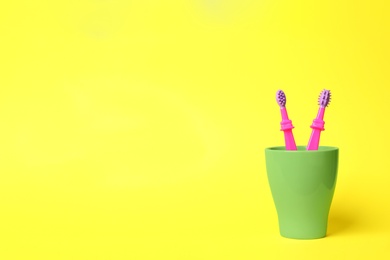 Photo of Baby toothbrushes in holder and space for text on color background