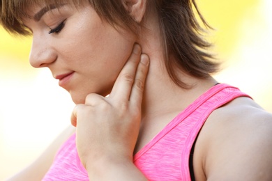 Young woman checking pulse after workout, closeup