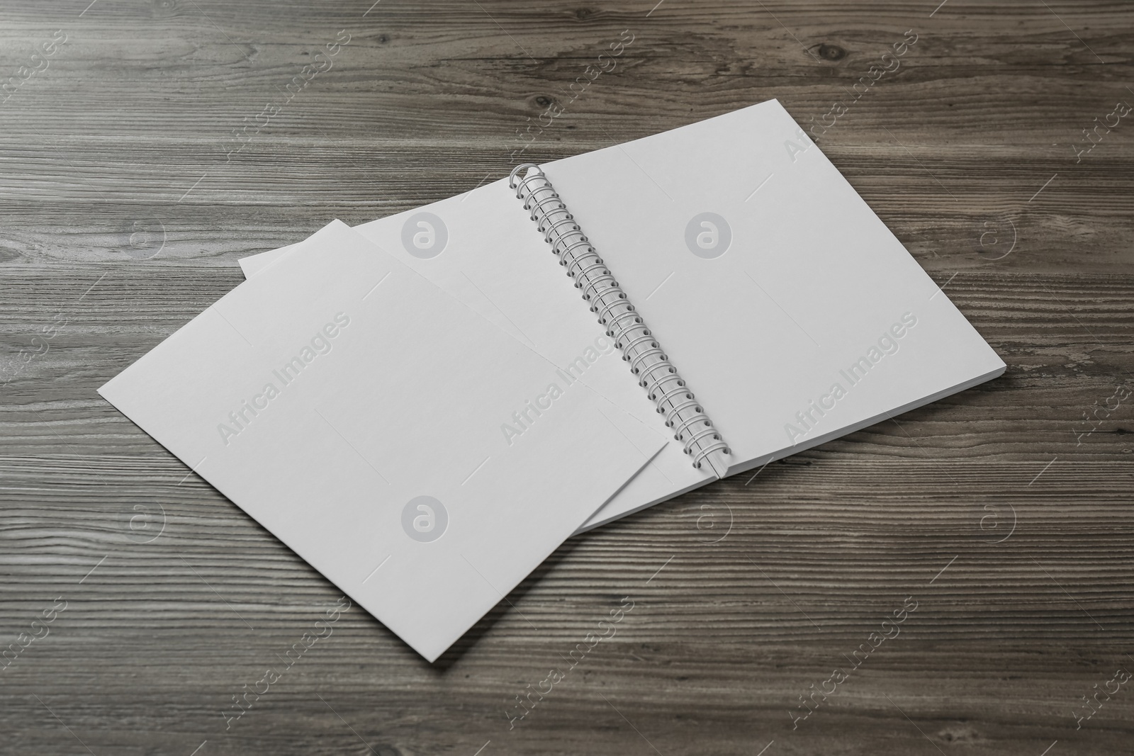 Photo of Sheet of paper and blank brochure on wooden table. Mockup for design