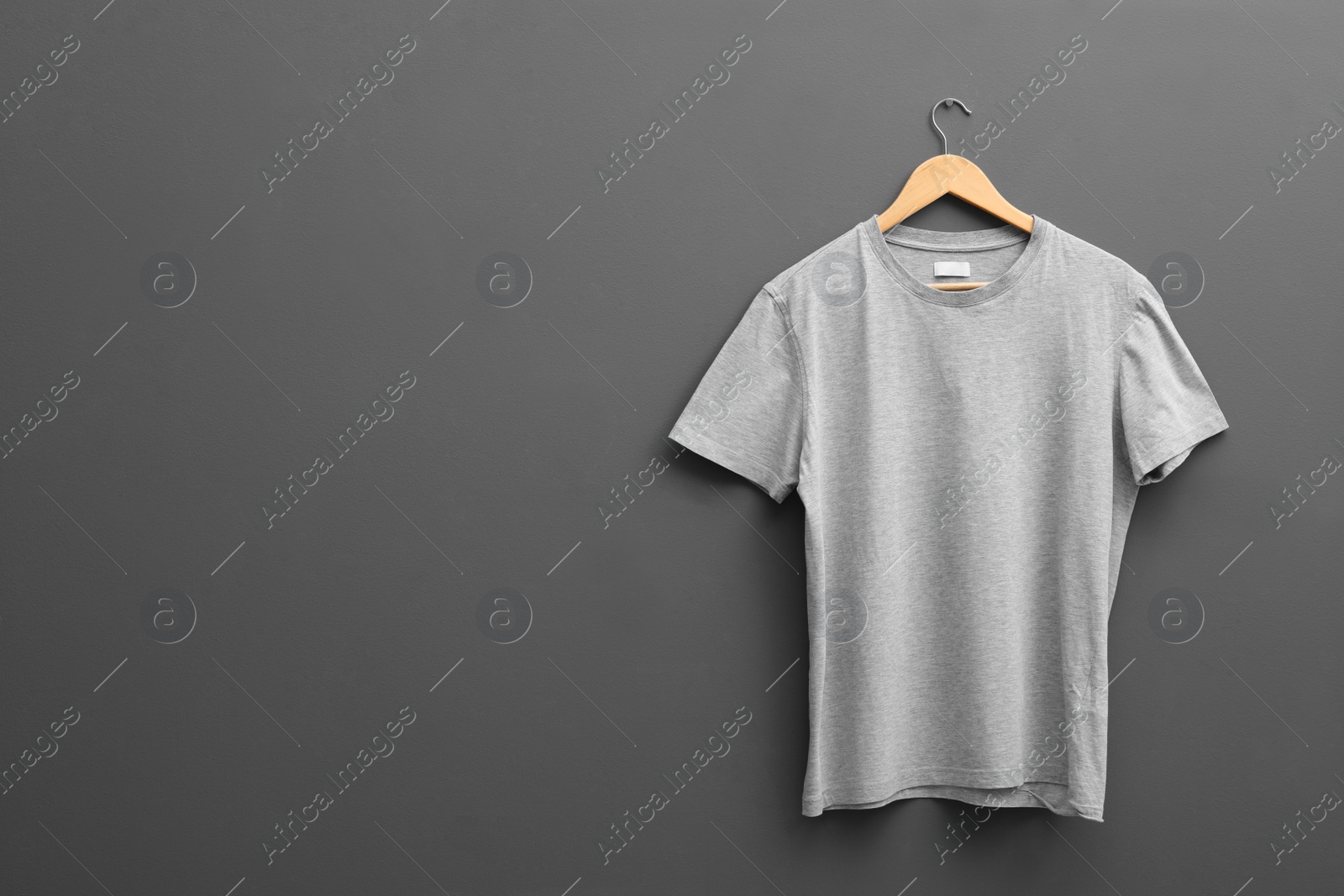 Photo of Hanger with blank t-shirt on grey background. Mockup for design