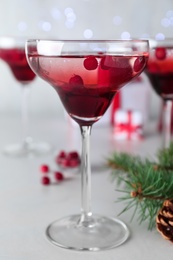 Photo of Delicious Christmas cocktail with liqueur on white table, closeup