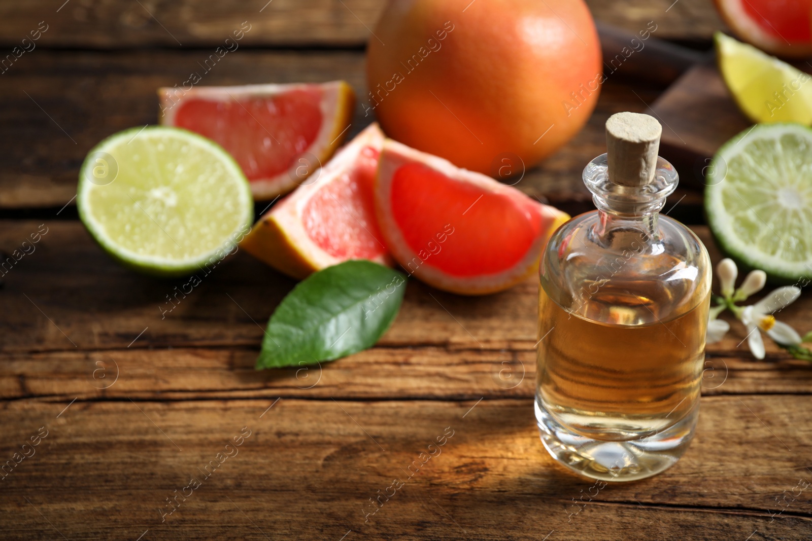 Photo of Citrus essential oil on wooden table. Space for text