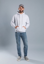 Full length portrait of young man in sweater on grey background. Mock up for design