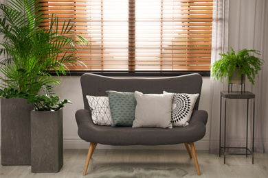 Photo of Stylish decorative pillows on grey couch indoors