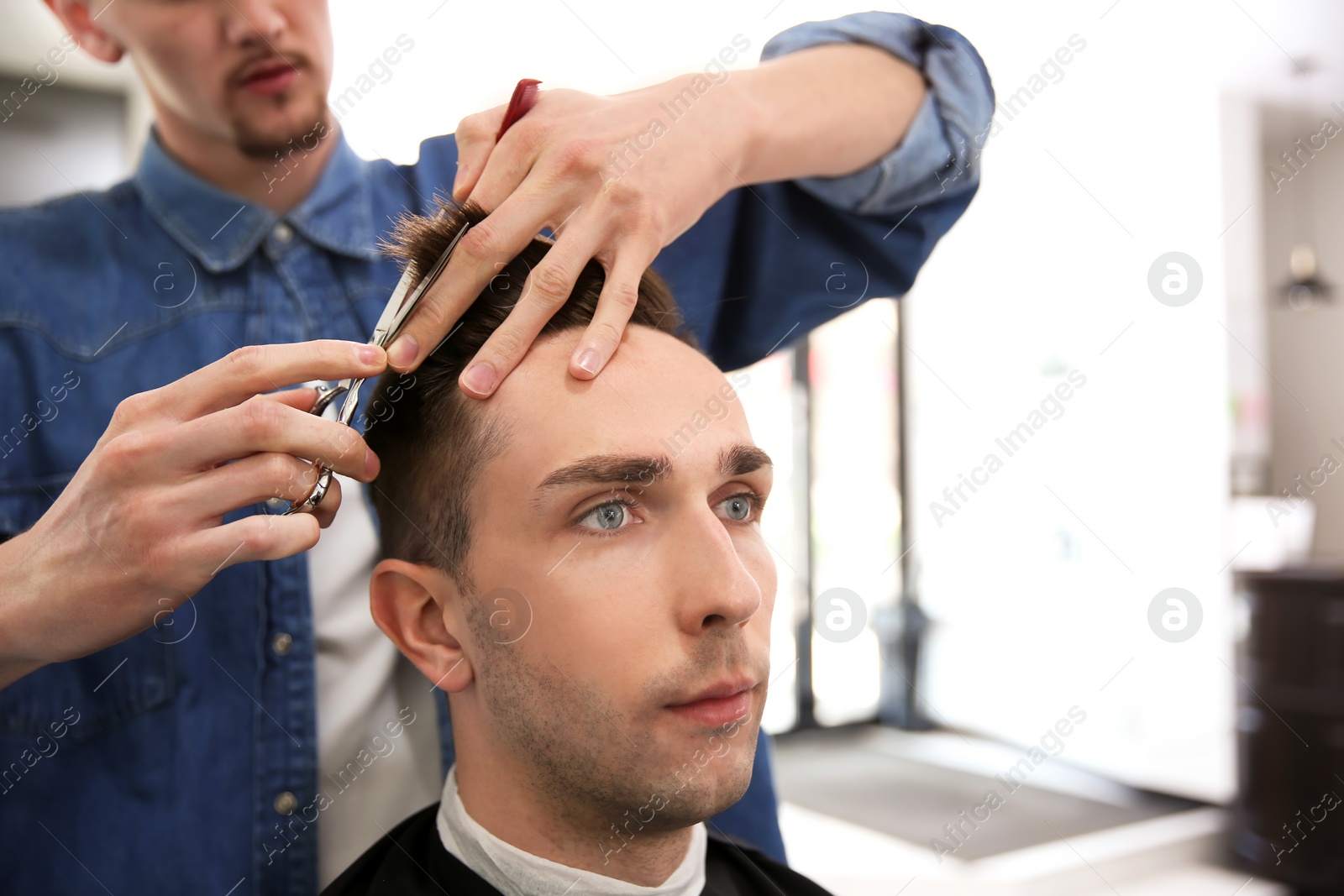 Photo of Professional barber working with client in hairdressing salon. Hipster fashion