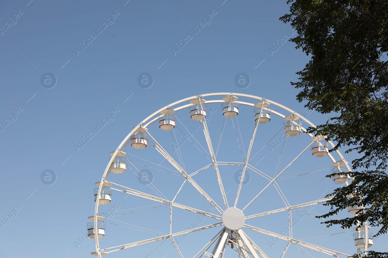 Photo of Beautiful white ferris wheel against blue sky