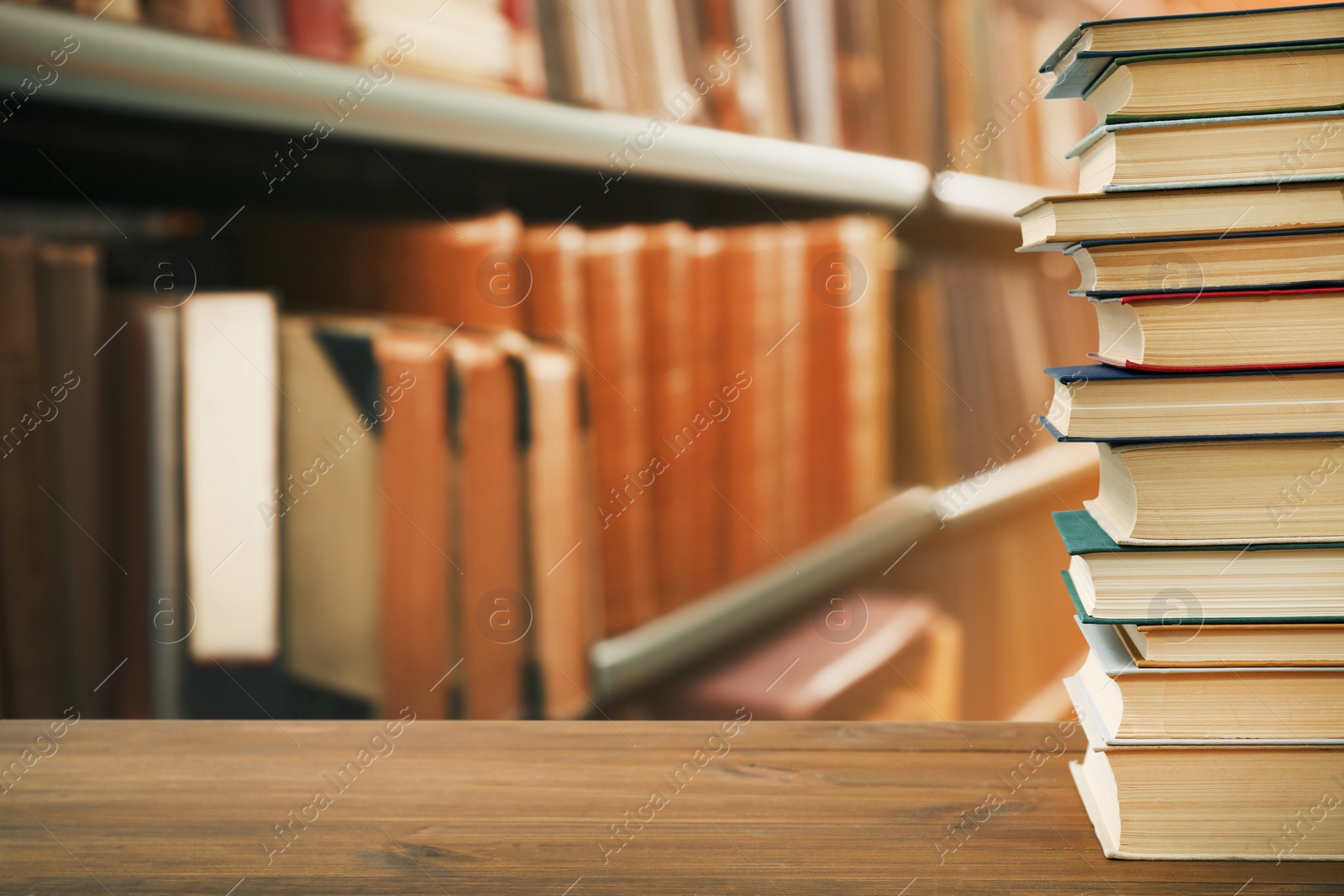 Image of Many books on wooden table in library. Space for text 