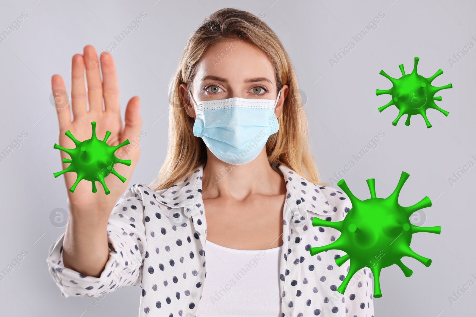 Image of Stop Covid-19 outbreak. Woman wearing medical mask surrounded by virus on light background