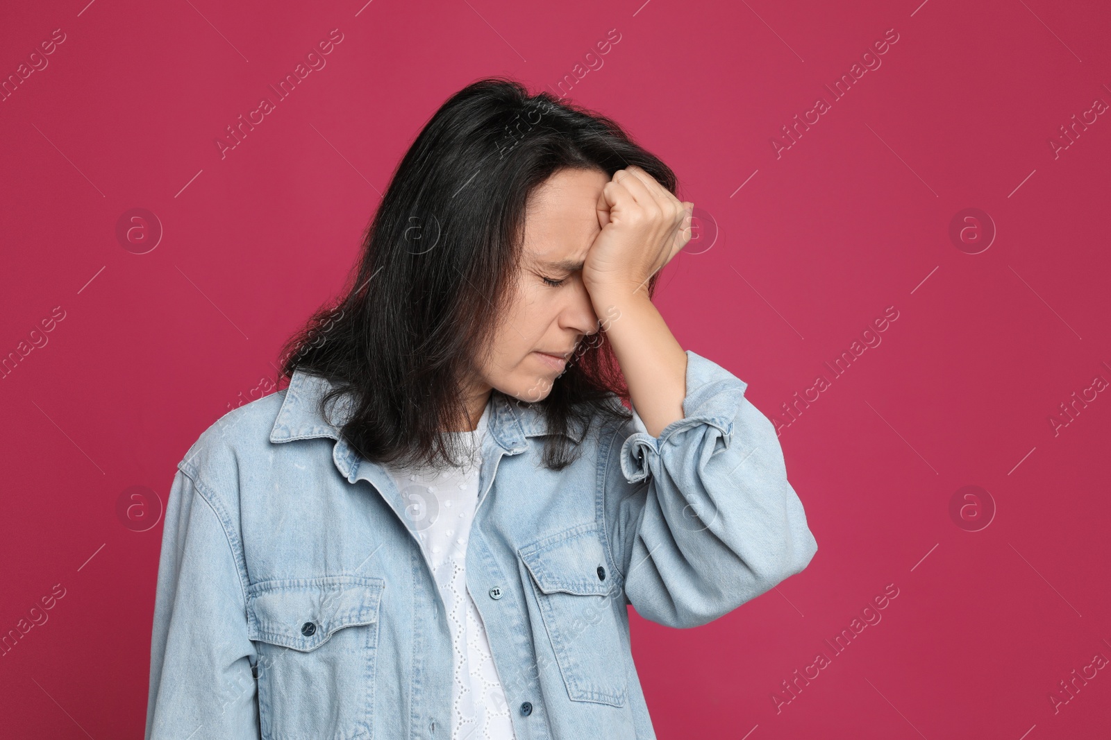 Photo of Mature woman suffering from headache on pink background