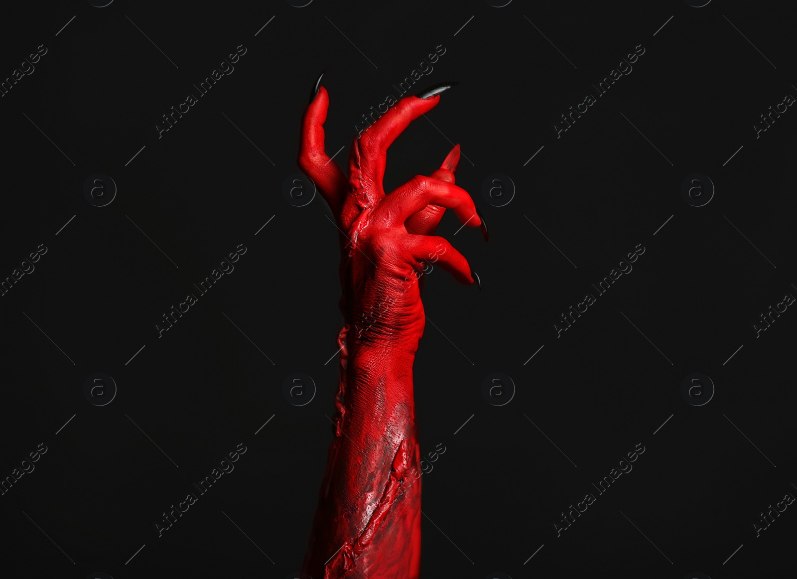 Photo of Scary monster on black background, closeup of hand. Halloween character