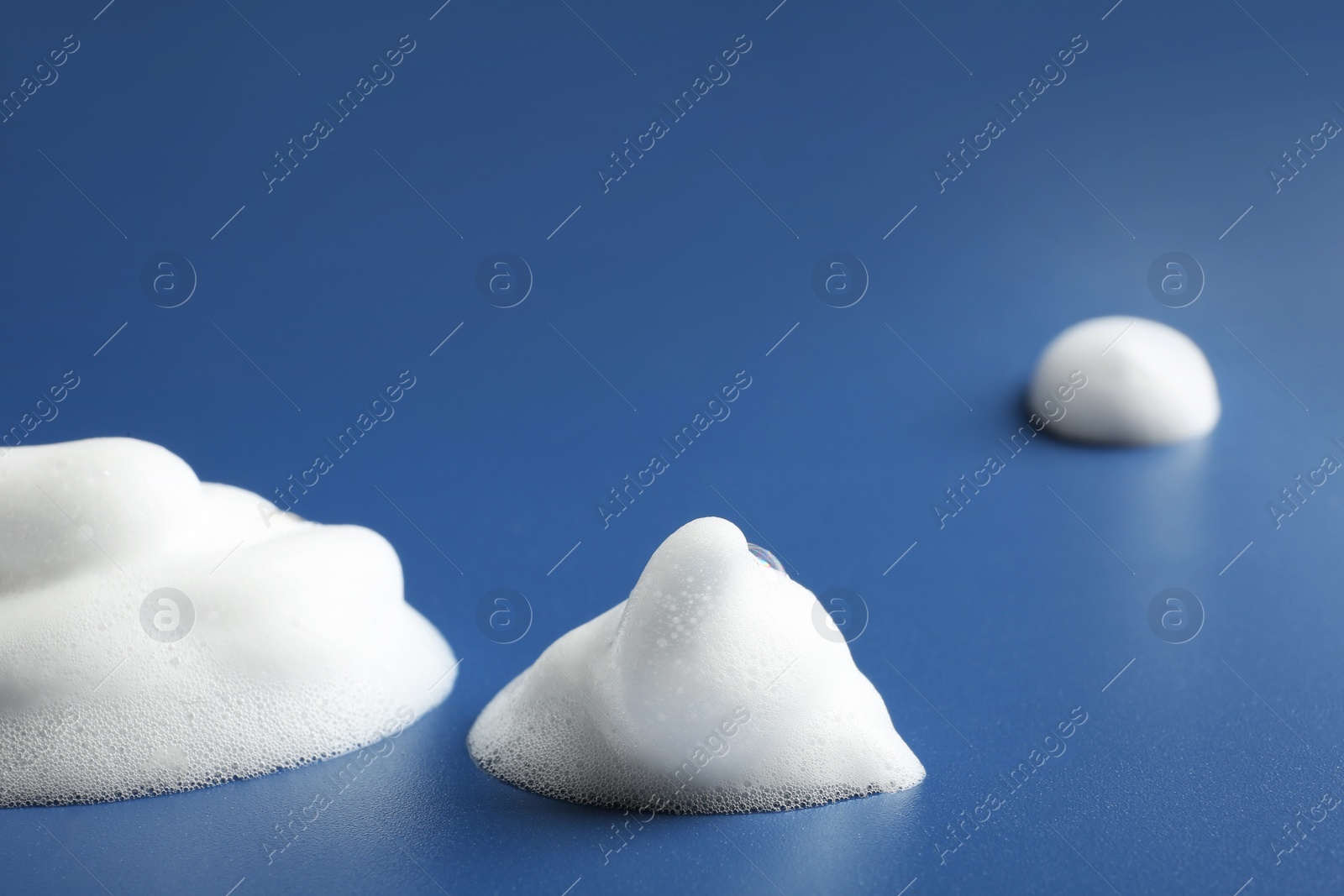 Photo of Drops of soap foam on color background. Space for text