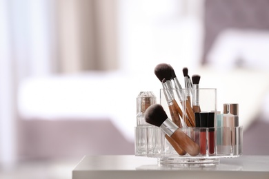 Organizer with makeup cosmetic products on table indoors. Space for text