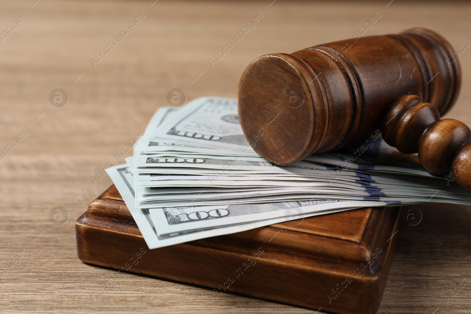 Photo of Judge's gavel and money on wooden table, closeup