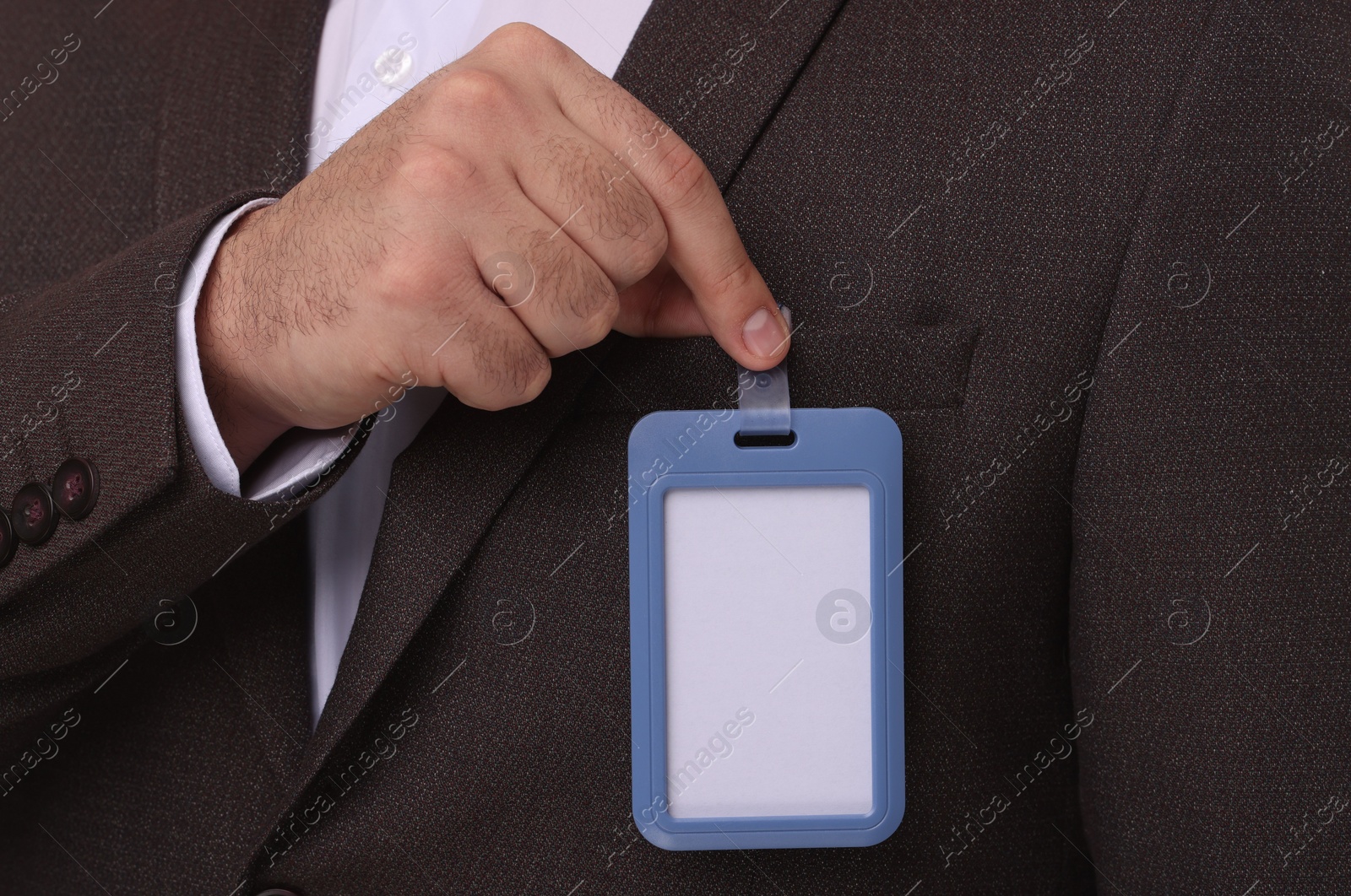 Photo of Man in suit with blank badge, closeup view