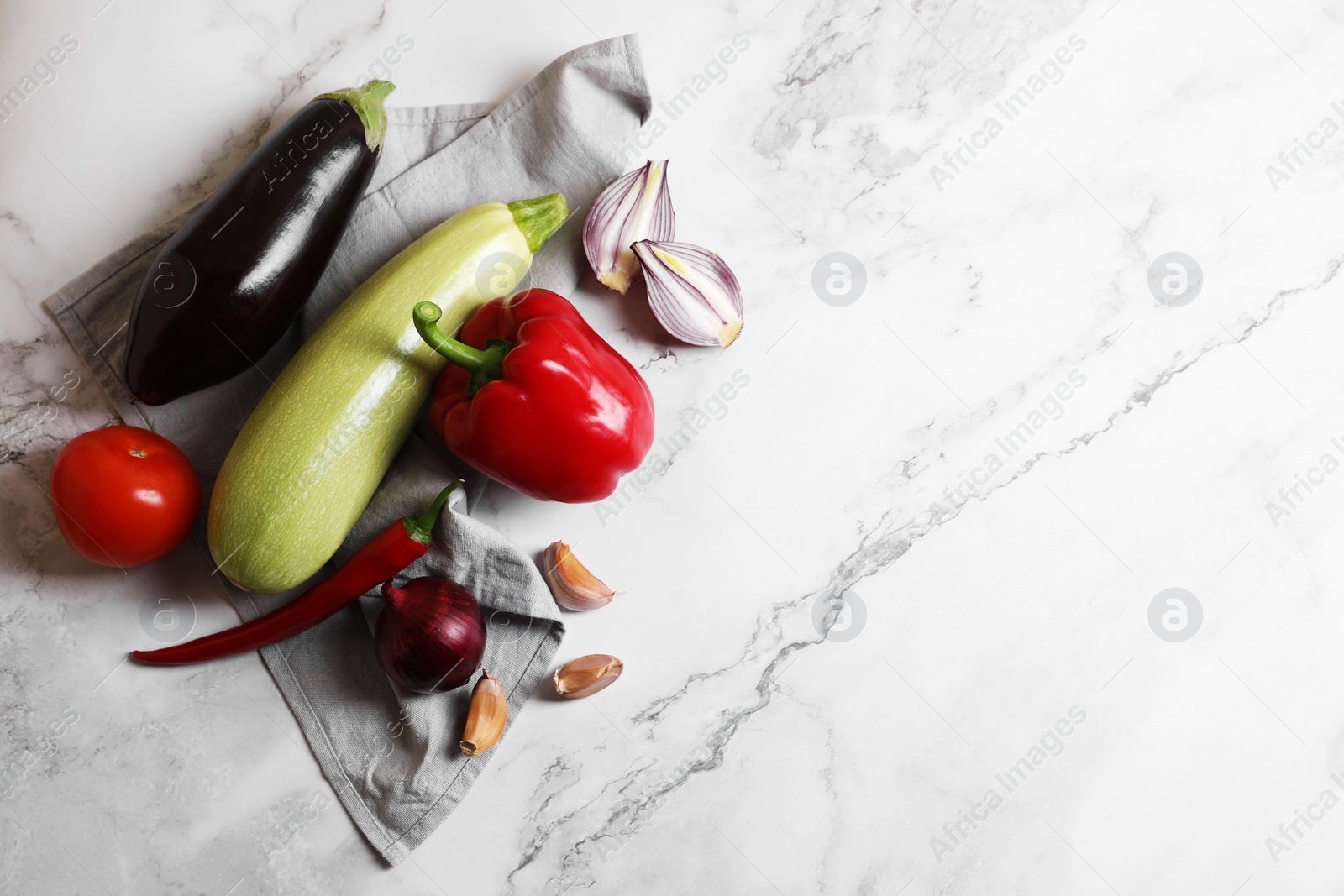 Photo of Fresh vegetables for ratatouille on white marble table, flat lay. Space for text