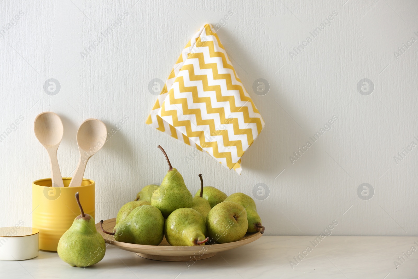 Photo of Plate with fresh ripe pears on white table. Space for text