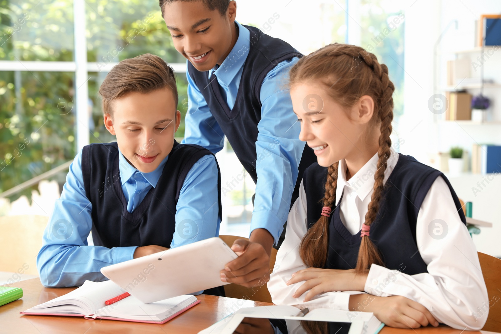 Photo of Teenage students in classroom. Stylish school uniform