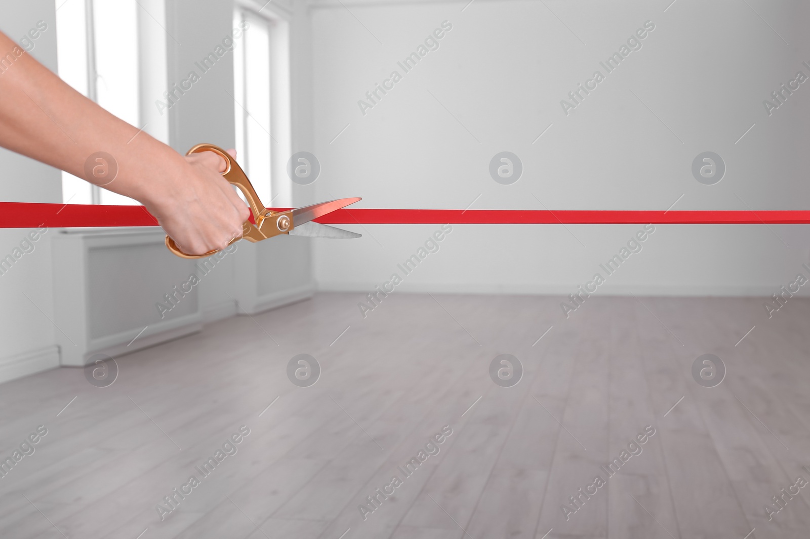 Photo of Woman cutting red ribbon on blurred background. Festive ceremony