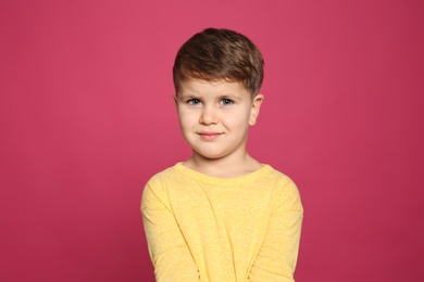 Photo of Portrait of cute little boy on color background