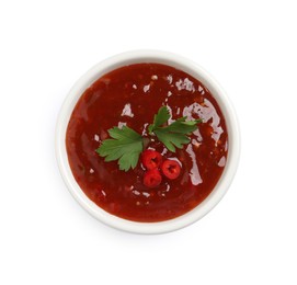 Photo of Spicy chili sauce with parsley on white background, top view