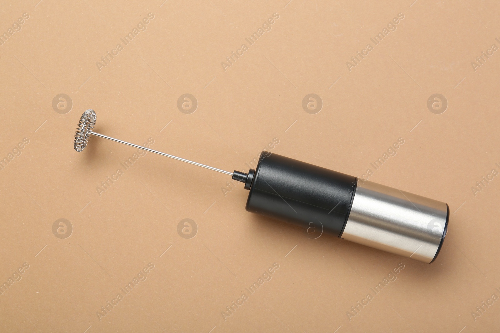 Photo of Milk frother wand on light brown background, top view