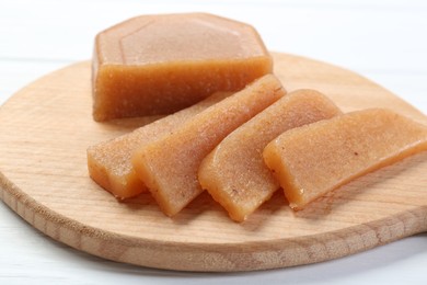 Photo of Tasty sweet quince paste on white wooden table, closeup