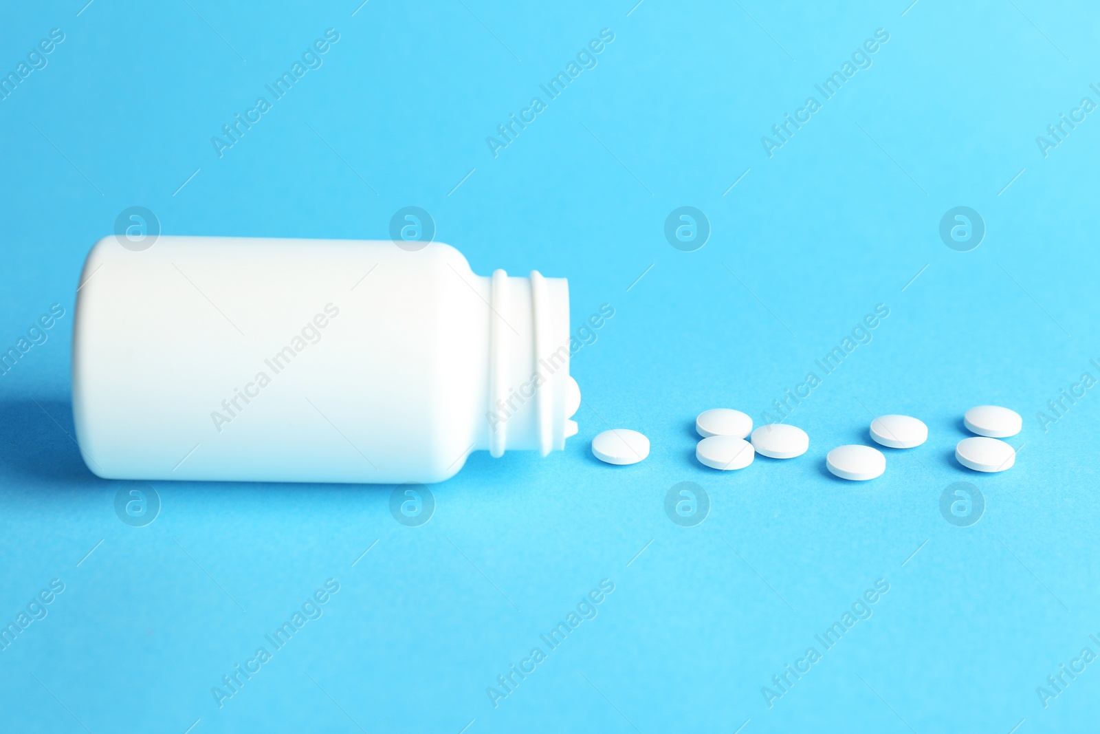 Photo of Bottle with pills on color background