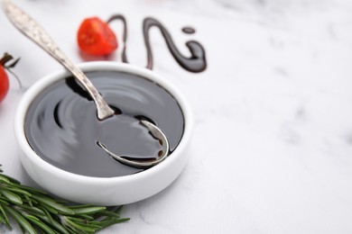 Photo of Organic balsamic vinegar and cooking ingredients on white marble table, closeup. Space for text