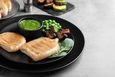 Photo of Grilled squid tubes served on grey table