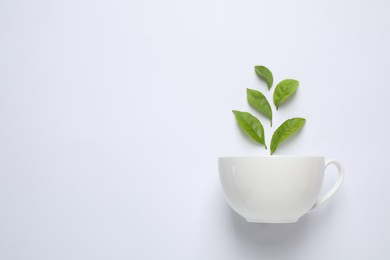 Fresh tea leaves and cup isolated on white