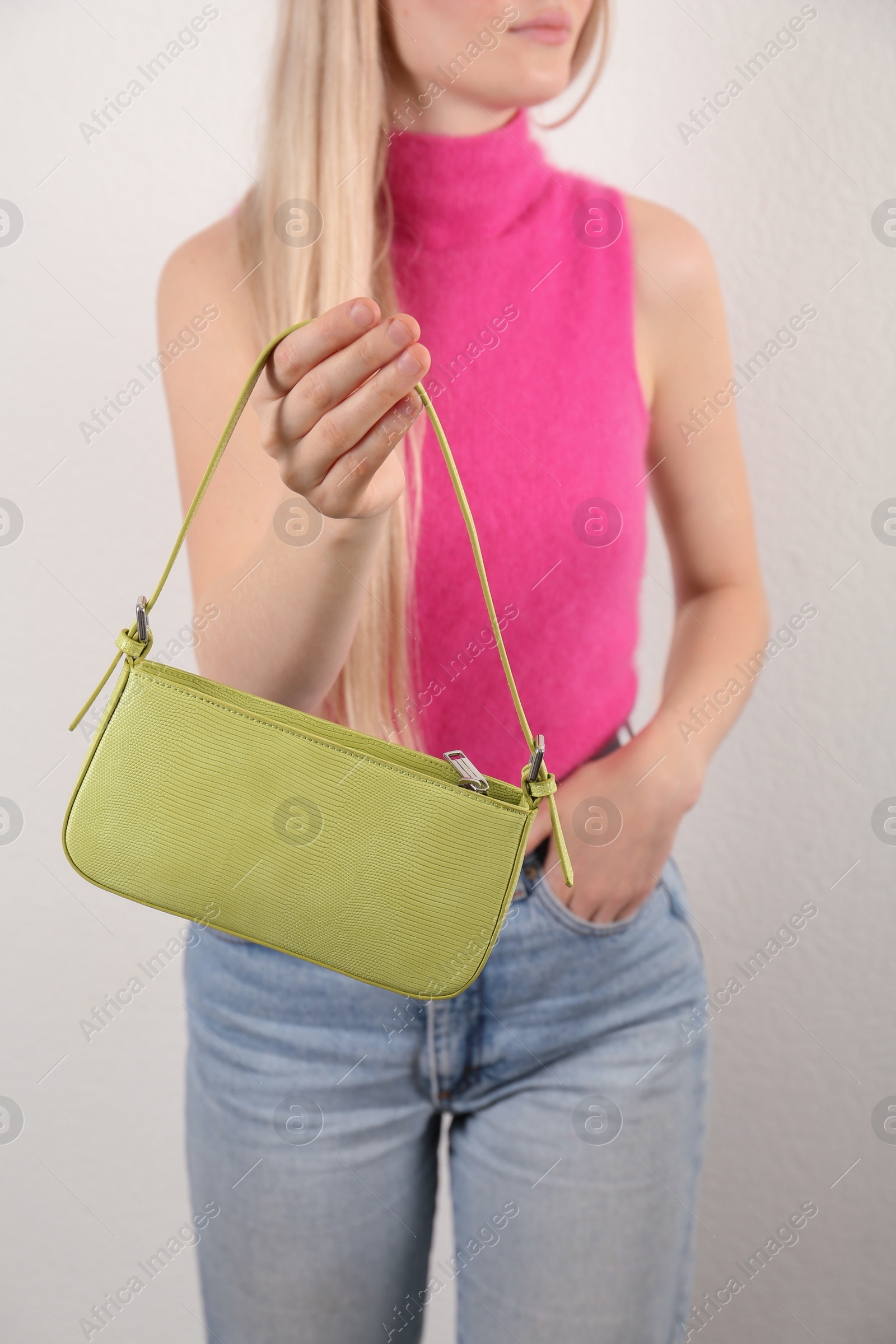 Photo of Woman holding stylish baguette handbag on white background, closeup