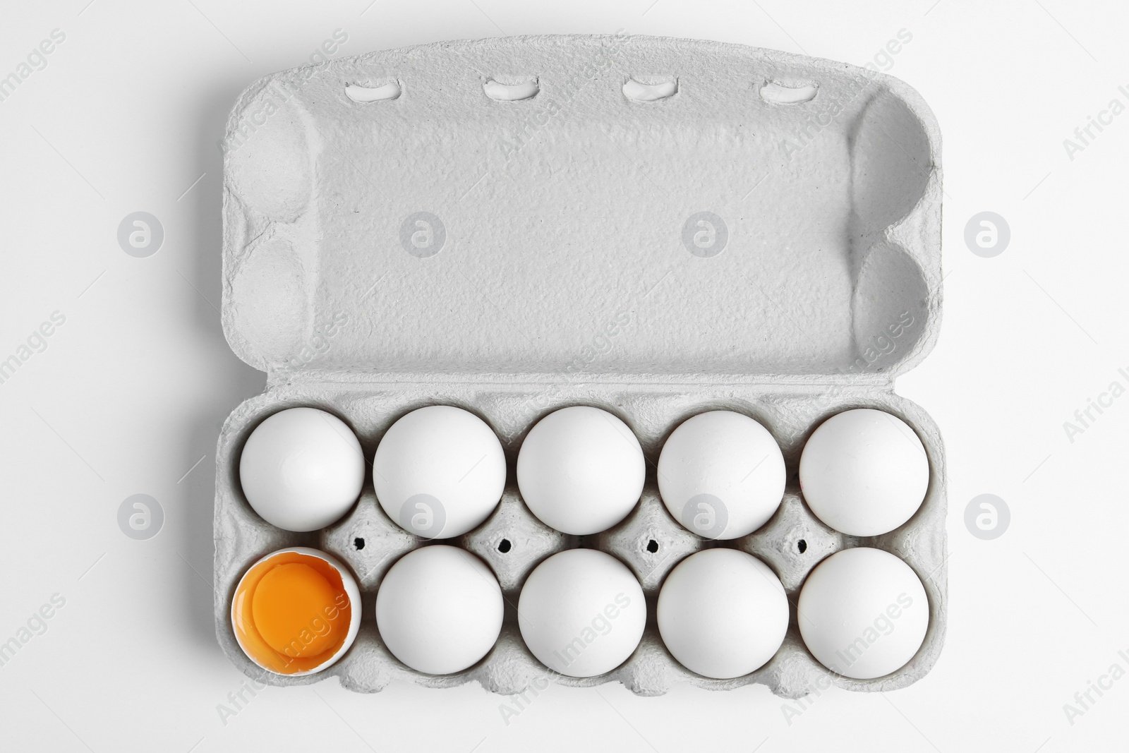 Photo of Fresh chicken eggs in box on white background, top view