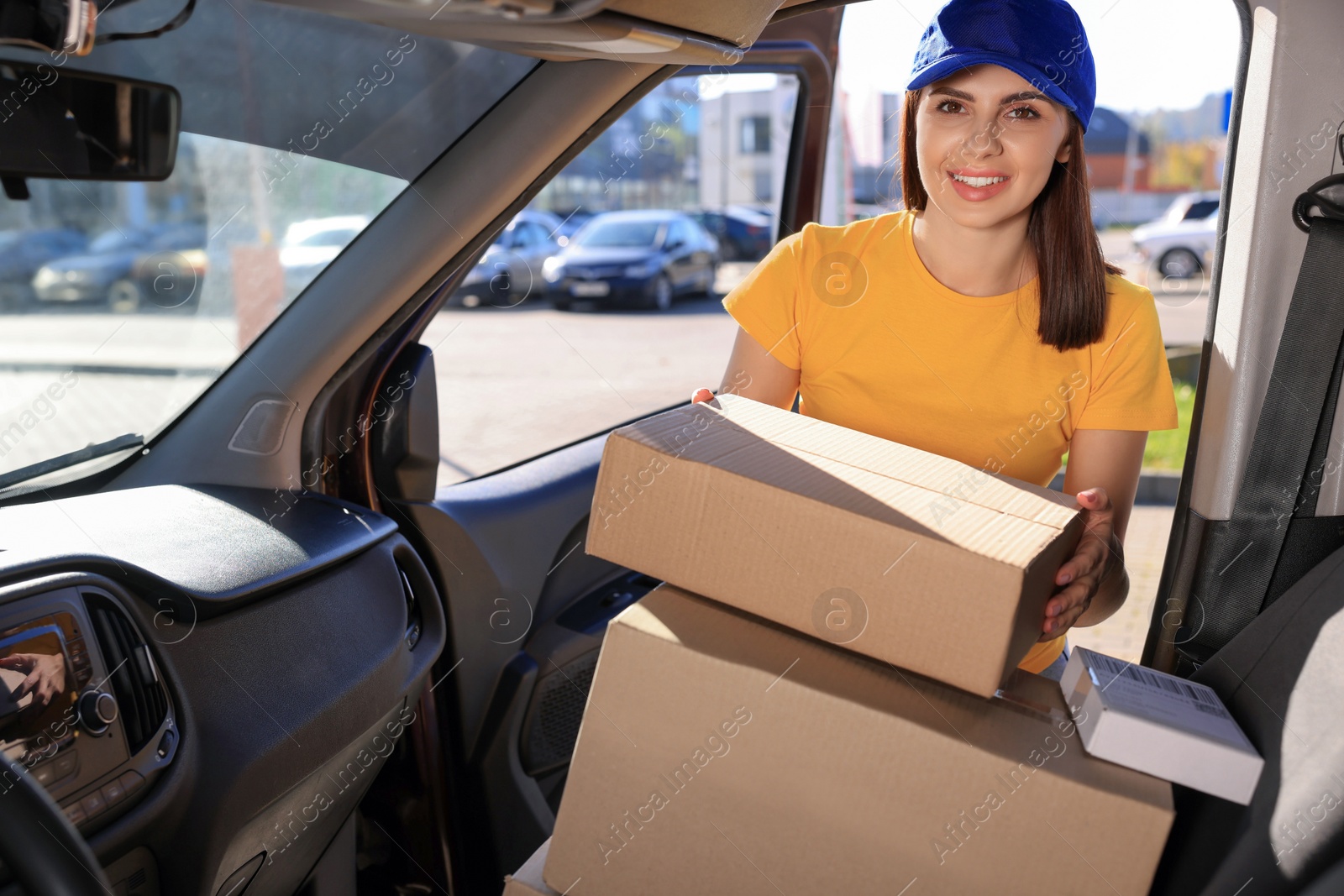 Photo of Courier taking parcel from car. Delivery service