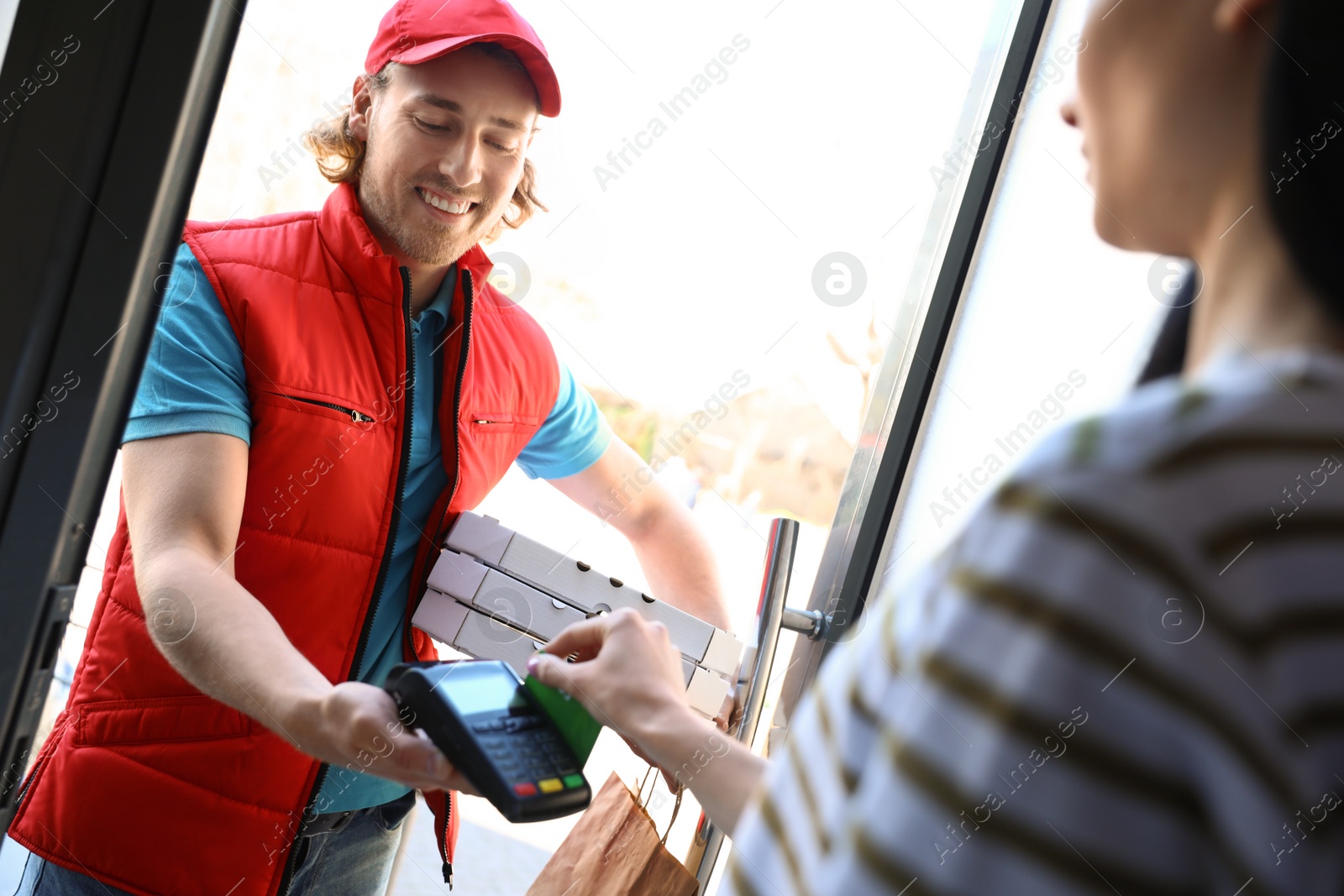 Photo of Woman paying for food delivery with credit card at door