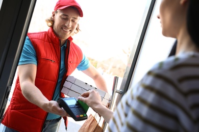 Woman paying for food delivery with credit card at door