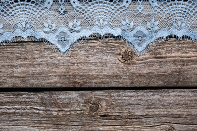 Beautiful lace on wooden table, top view. Space for text