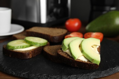 Photo of Slices of bread with different toppings on slate plate