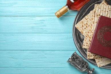 Photo of Flat lay composition with symbolic Passover (Pesach) items on wooden background, space for text