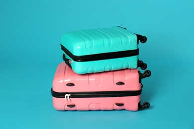 Stylish carry on suitcases on color background